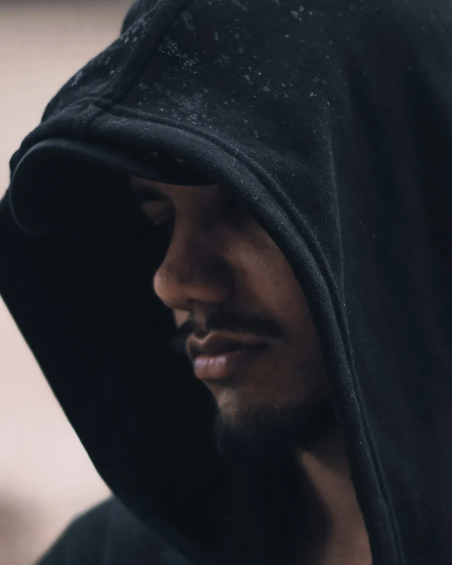 Close-up of a black hood pulled low over a man's face